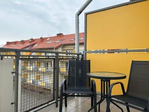 a table and chairs on a balcony with a yellow wall at Apartament BARTUŚ do 4 osób - STEGNA mierzeja wiślana in Stegna