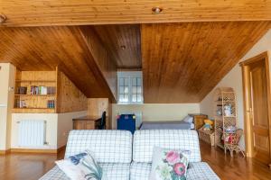 a living room with a couch and wooden ceilings at Cuencaloft Casa Rural Lagunas de Arcas in Arcas