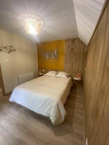 una camera da letto con un grande letto bianco in una stanza di Le Nid du Cygne a Houlle