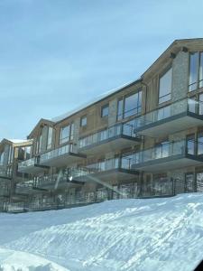 an apartment building with snow in front of it at Fjellnest Hemsedal in Hemsedal