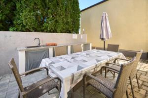 a table and chairs and an umbrella on a patio at App Forza in Umag