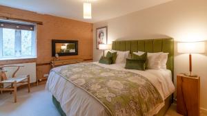 1 dormitorio con 1 cama grande y TV en Wynyard Mill en Malmesbury