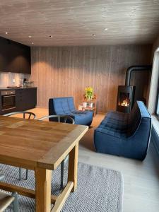 a living room with blue furniture and a fireplace at Fjellnest Hemsedal in Hemsedal