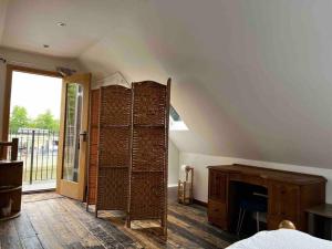 an attic room with a fireplace and a window at Quirky 1 bedroom barn on the river in Arundel in Arundel