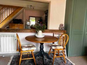 una mesa y sillas en una cocina con escalera en Quirky 1 bedroom barn on the river in Arundel, en Arundel