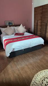 a bedroom with a large bed with a red and white blanket at Feng Jing Yuan in Pingtung City