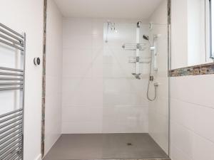a white bathroom with a shower with a glass door at Strawberry Bank - Nuthatch in Holsworthy +29 photos