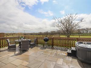 a patio with a fence and a hot tub at Strawberry Bank - Nuthatch in Holsworthy