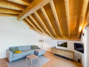 uma sala de estar com um sofá azul e uma televisão em Gipfelkreuz mit Sauna em Garmisch-Partenkirchen