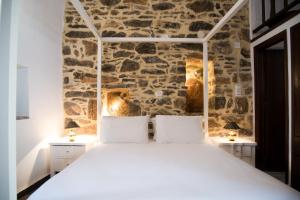 a bed in a room with a stone wall at Lida Mary in Mesta