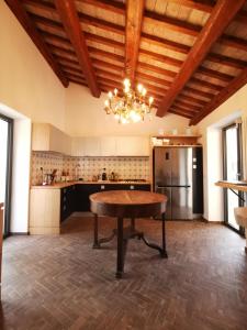 a large kitchen with a table and a chandelier at Corte Signoretti - Hystorical Villa in Canale Monterano