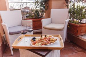 a plate of food on a table with wine glasses at My Spanishsteps in Rome