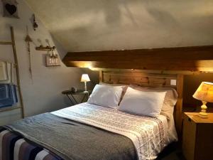 a bedroom with a large bed with white pillows at Chambres d'Hôtes Lefoulon in Pirou