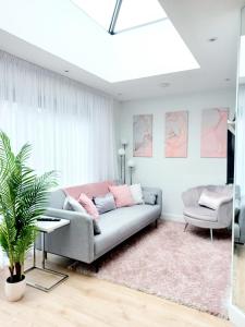 sala de estar con sofá y silla en 'The Limes' - Air-Con Two Double Bedroom Holiday House with Private Garden en Kent