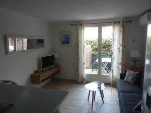 a living room with a couch and a tv at Mas Provençal in Le Lavandou