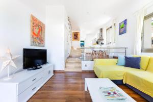 een woonkamer met een gele bank en een tv bij Bahamas 2 in Son Serra de Marina