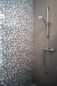 a shower in a bathroom with a tiled wall at HY 2 SIBIU in Şelimbăr
