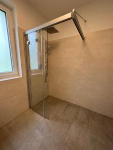 a shower with a glass door in a bathroom at Himmelblau by Strandclub Velden in Velden am Wörthersee