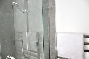 a bathroom with a glass shower with a toilet at Zen hideaway in Aotea in Porirua