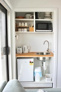 a kitchen with a refrigerator and a sink at Zen hideaway in Aotea in Porirua