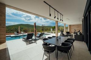 a dining room with a table and chairs and a pool at Villa Vitrenik, Cista Velika, Makarska-Imotski in Velika Cista