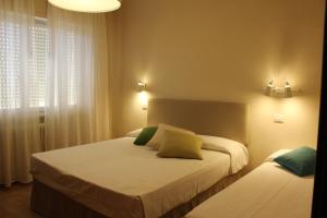 a bedroom with two beds and a window at Hotel Ristorante Il Gabbiano in Cecina