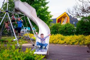 a young boy on a slide at a playground at Kolping Hotel Spa & Family Resort in Hévíz
