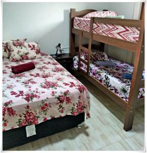 a bedroom with two bunk beds and a bed with a flowery blanket at Pousada Seu Jorge in Campinas