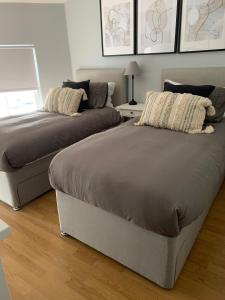 two beds sitting next to each other in a bedroom at Prince Arthur Apartment in Walton on the Hill