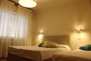 a bedroom with two beds and a window at Hotel Ristorante Il Gabbiano in Cecina