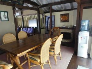 a dining room with a table and chairs and a refrigerator at Ishigakijima Akagawara Villa in Ishigaki Island