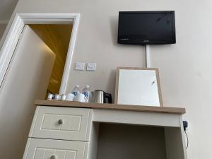 a room with a desk with a tv and a mirror at The Sandrock in Clacton-on-Sea