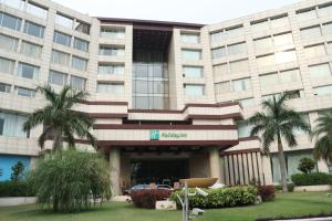 un grand bâtiment avec des palmiers devant lui dans l'établissement Holiday Inn Chandigarh Panchkula, an IHG Hotel, à Chandigarh