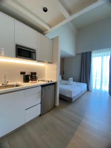 una cocina con fregadero y una cama en una habitación en Barbie Hotel Apartments, en Ialisos