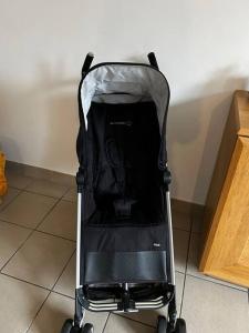 a black baby stroller sitting on a floor at Grand T4 à 150m de la Plage in Le Portel