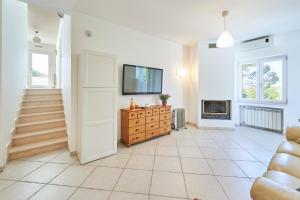a large living room with a tv and a fireplace at Villa Luminosa in Brindisi