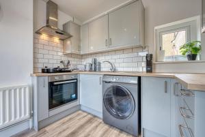 una cucina con lavatrice e asciugatrice di Buckwell Heights - 2 Bedroom Free Parking Wifi Sky TV a Wellingborough