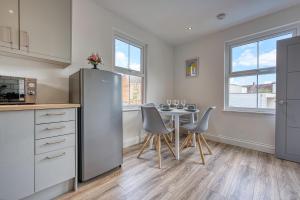 cocina con mesa, sillas y nevera en Buckwell Heights - 2 Bedroom Free Parking Wifi Sky TV en Wellingborough