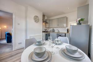 a dining room with a white table and chairs at Buckwell Heights - 2 Bedroom Free Parking Wifi Sky TV in Wellingborough