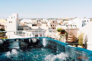 a hot tub on a balcony with a view of a city at Modern Apartments in Malta's charming Mosta in Mosta