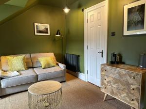 a living room with a couch and a table at Rooms Above Sugar Boat in Helensburgh