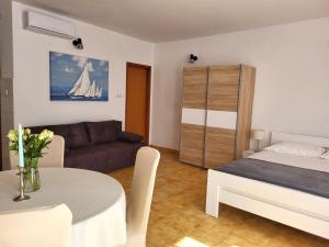 a room with a bed and a couch and a table at Apartments Gorana in Novi Vinodolski