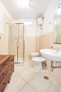 uma casa de banho com um WC, um lavatório e um chuveiro em Villa Luminosa em Brindisi
