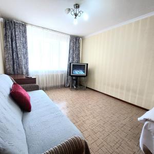 a hotel room with a bed and a television at Аэропорт Астана 5 минут юг1 in Astana
