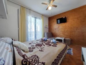 Apartment and Room Marica في بونات: غرفة نوم بسرير ومروحة سقف