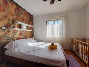 a bedroom with a bed with a crib in it at Apartment and Room Marica in Punat