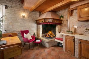 een keuken met een open haard, rode stoelen en een tafel bij Apartment Antonia in Novigrad Istria