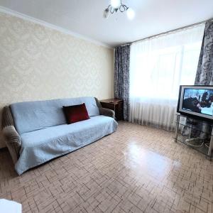 a living room with a couch and a television at Аэропорт Астана 5 минут юг1 in Astana