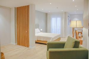 um quarto de hotel com uma cama e um sofá em Casal da Penha Apartments no Funchal