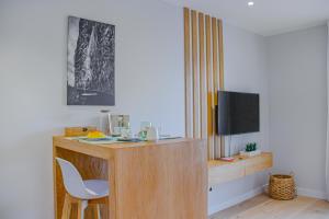 Habitación con escritorio, silla y TV. en Casal da Penha Apartments, en Funchal